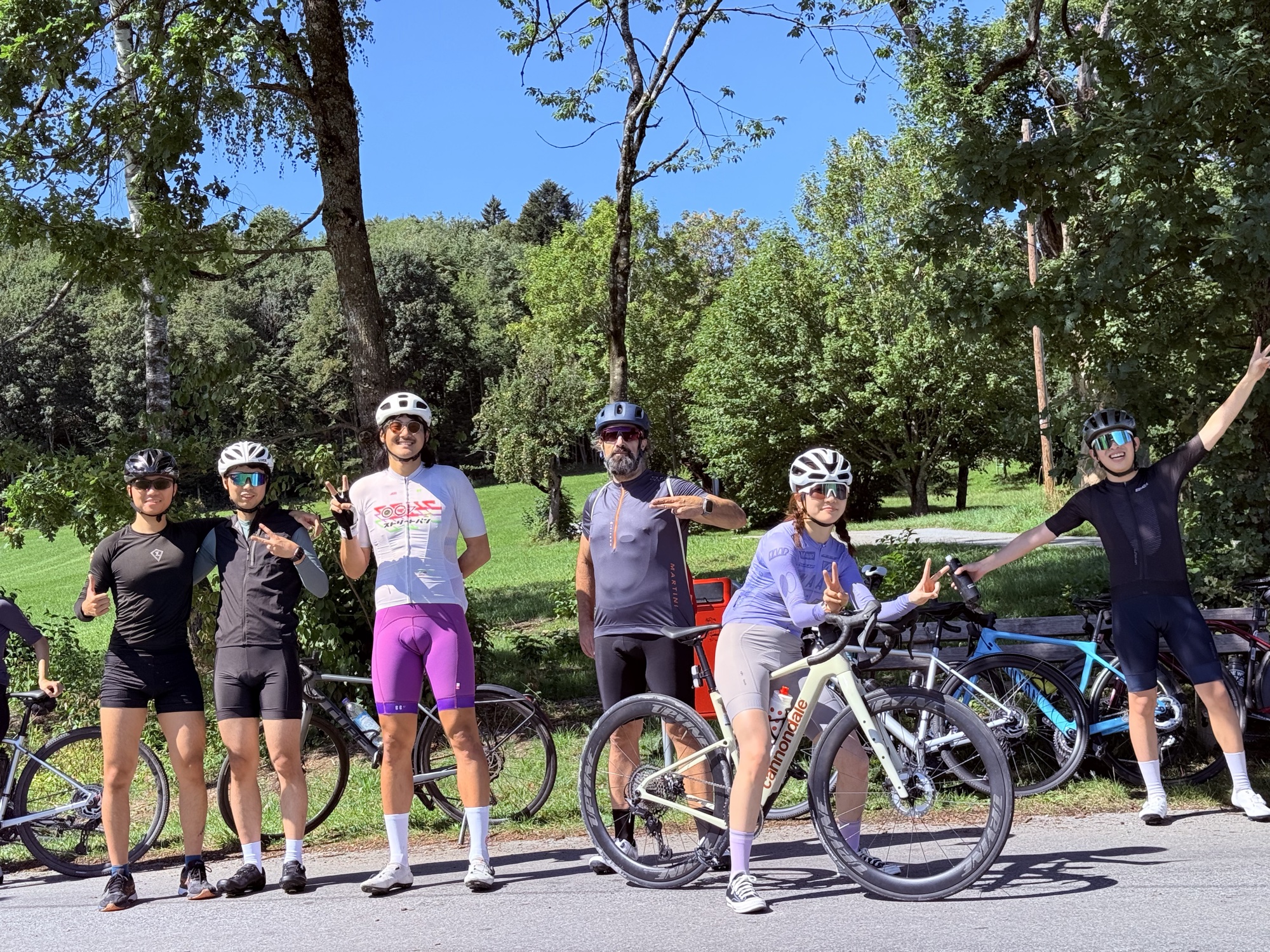 Riders posing together at the roadside, striking all kinds of poses